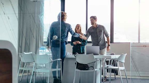 Employees shaking hands with client