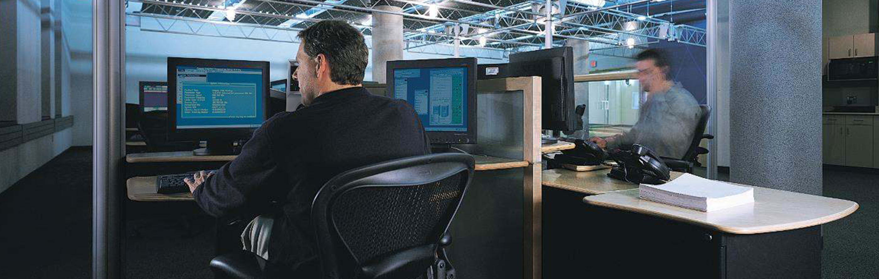 Interiors of an office with people working at desktops
